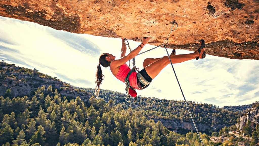 mujer escalando en ruta de escalada deportiva