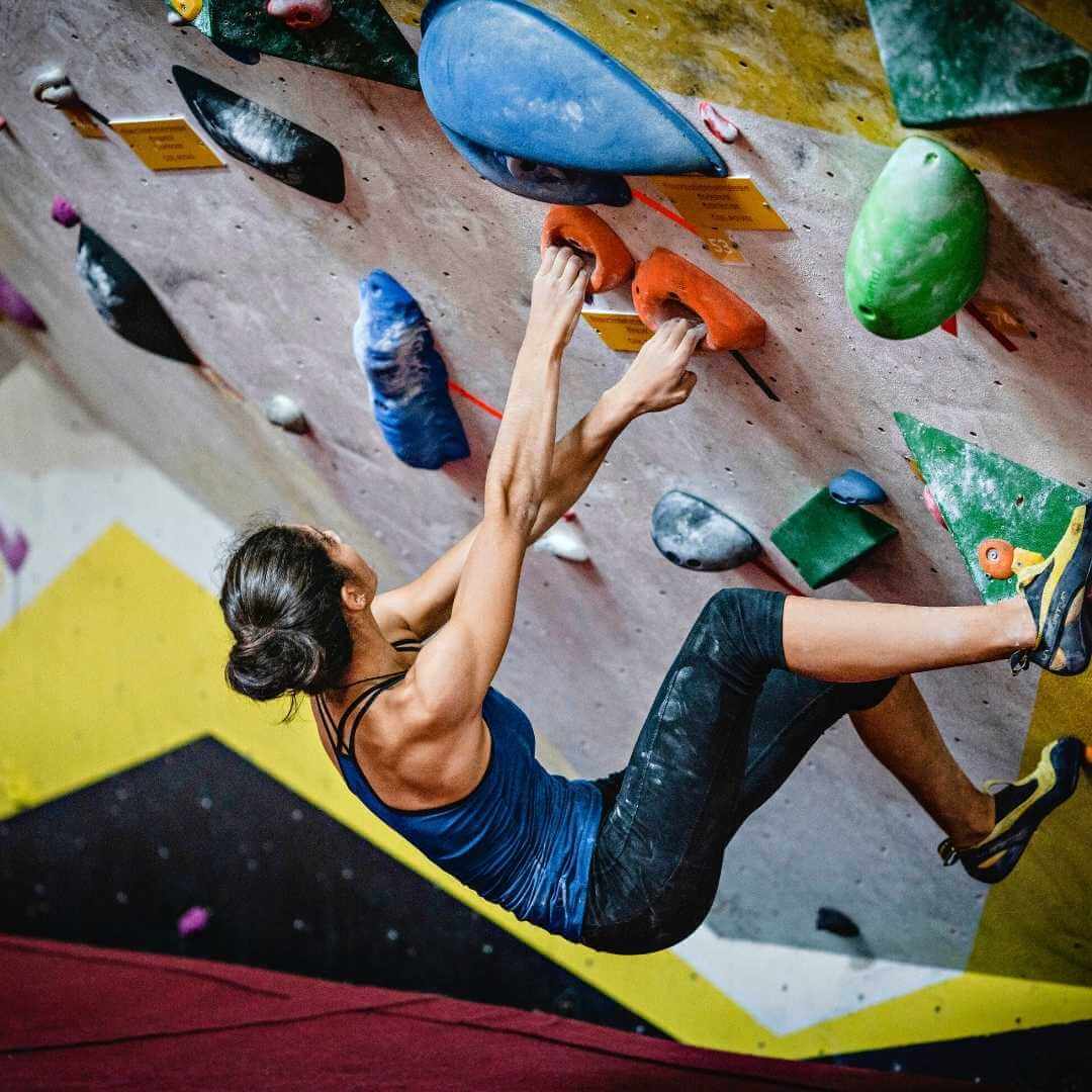 mujer en muro de escalada o rocodromo